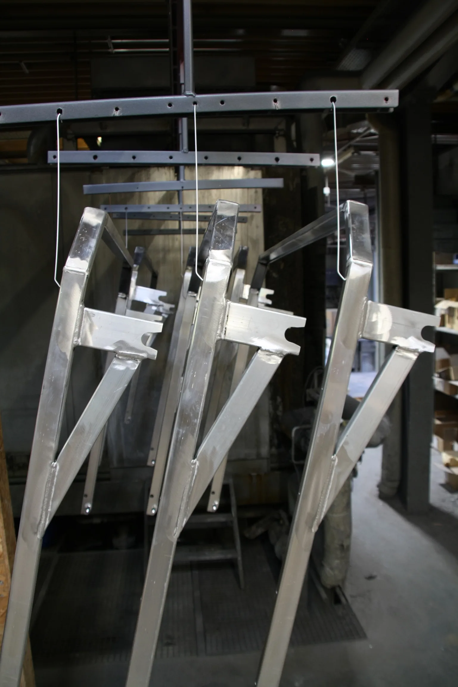 Aluminium-Schweißkonstruktionen hängen am Gehänge der Durchlaufanlage bei Proteccolor.